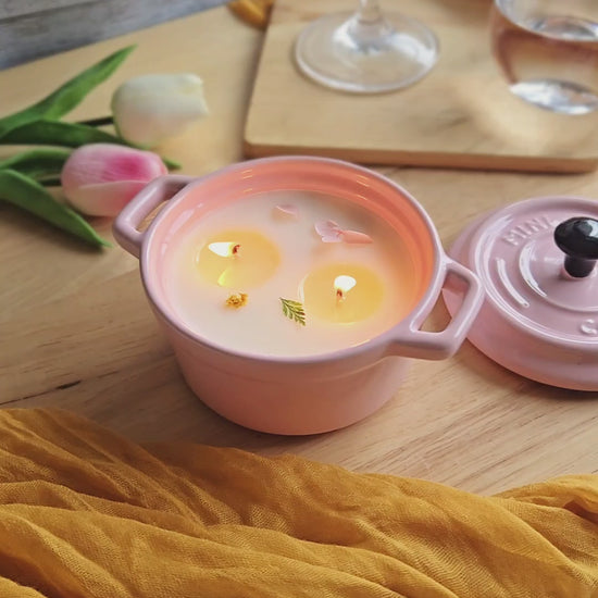a pink soup candle by Candle Tales is lit on a dinning table